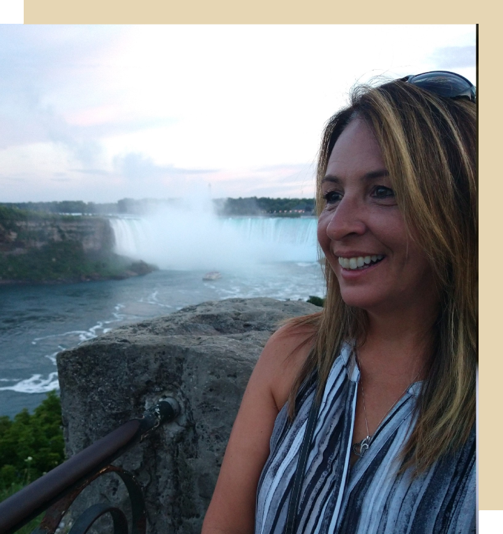 A woman standing on top of a cliff near the ocean.